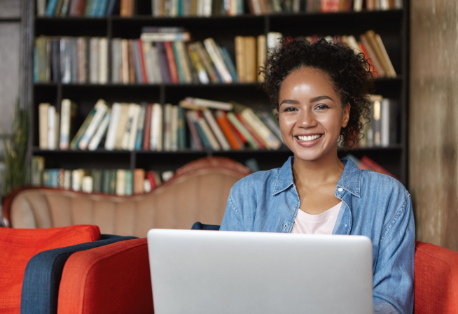 Etudiante travaillant dans une bibliothèque sur son ordinateur